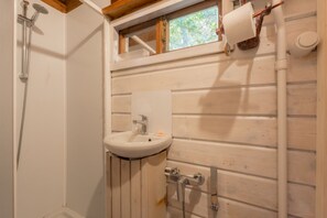 A bathroom with a wooden wall, a sink, a shower, and a toilet. - APP.TI CHALET INES SECCIONE - CHALET SECCIONE 1 (Portoferraio)
