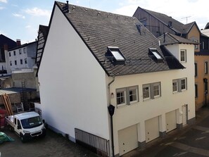 A two-story building with a sloped roof, dormer windows, and a garage.