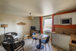 A compact living space with a dining area, kitchen, and seating.