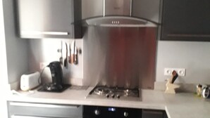 Una cocina moderna con campana de acero inoxidable, horno empotrado y tostadora.