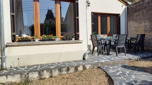 A building with large windows, outdoor seating, and potted plants. - Maison 4/5 Personnes Avec Jardin Langeais Centre (Langeais)