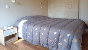 A bedroom with a bed, a bedside table, and a wall-mounted light fixture. - Maison 4/5 Personnes Avec Jardin Langeais Centre (Langeais)