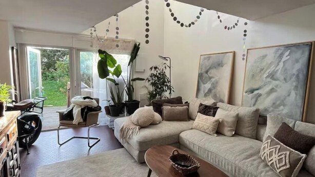 Un salon moderne avec un canapé, une table basse et de grandes fenêtres.
