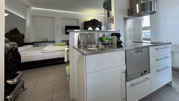 A modern kitchen with a built-in dishwasher, a stainless steel sink, and a microwave.