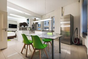 Eine moderne Küche mit Esstisch, Stühlen und einem Kühlschrank.