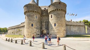 A historic castle with two prominent towers, a central entrance, and a surrounding wall. - Poterne du Tricot - Studio - 20m² - Maximum 2 Personnes (Guérande)