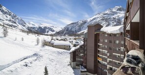 A snow-covered mountain town with a multi-story hotel featuring balconies and a view of the surrounding mountains. - Résidence La Daille - Val-d'Isère (Val-d'Isere)