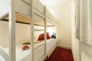 A bunk bed room with a red striped carpet, a small toy car, and a panda plush toy on the lower bunk. - Résidence La Daille - Val-d'Isère (Val-d'Isere)
