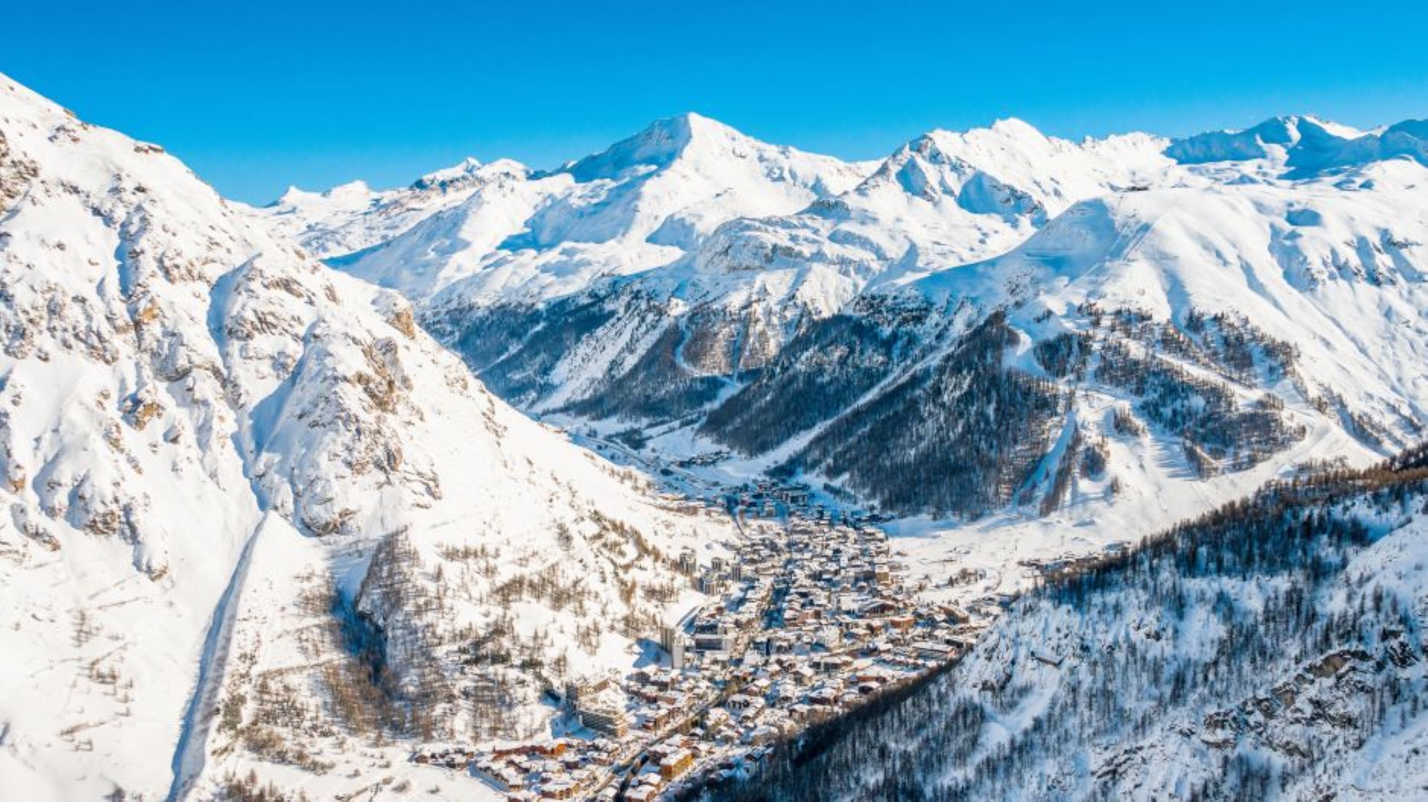 A snow-covered mountain range with a valley town.
