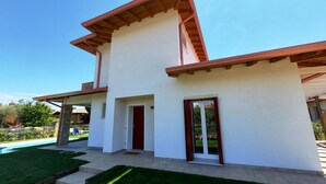 A two-story house with a white exterior and brown roof. There is a front door and a window on the ground floor. - Villa Laura, with private heated pool and garden (Manerba del Garda)