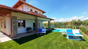 A house with a covered patio, a swimming pool, and outdoor seating. - Villa Laura, with private heated pool and garden (Manerba del Garda)