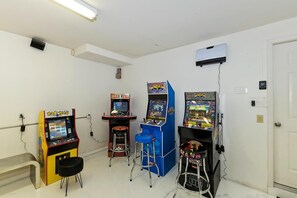 Una habitación con máquinas de videojuegos, un banco y una puerta.