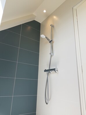 Een douche, een haardroger, handdoeken, toiletpapier
