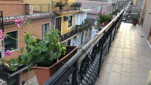 A balcony with potted plants and a view of neighboring buildings. - La Casa dei Gemelli (Priolo Gargallo)