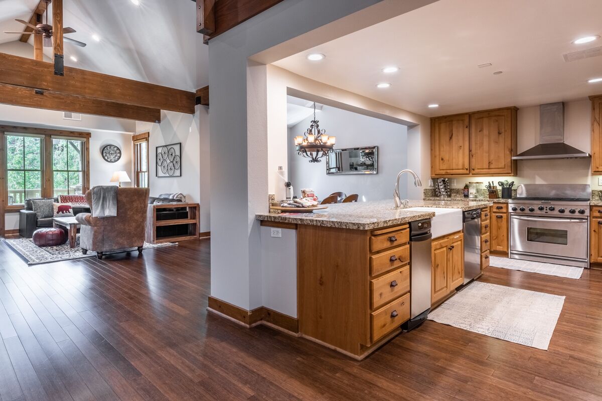 A spacious kitchen with wooden cabinets, a central island, and a large stove.