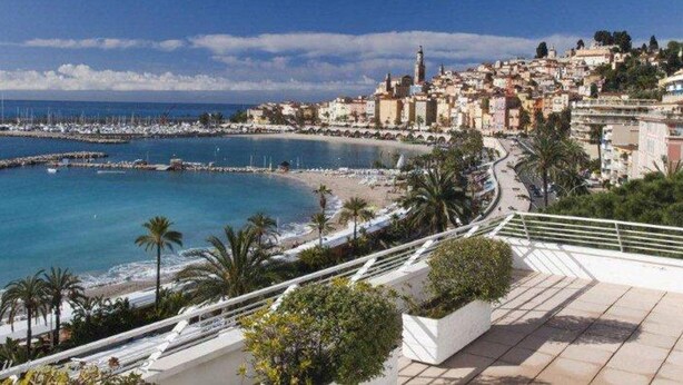 A coastal cityscape with a beach, a marina, and a prominent tower. - Superb air-conditioned apartment with large terrace and parking in Menton (Menton)