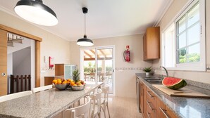 A modern kitchen with granite countertops, white chairs, and a large window. - Large villa for 10 with private pool and beach location, near Alcudia, Mallorca (Alcudia)