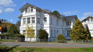 A large, white, multi-story building with a symmetrical facade, large windows, and a traditional architectural style. - Villa zur See 10 - modern maritime vacation apartment (Heringsdorf (Seebad))