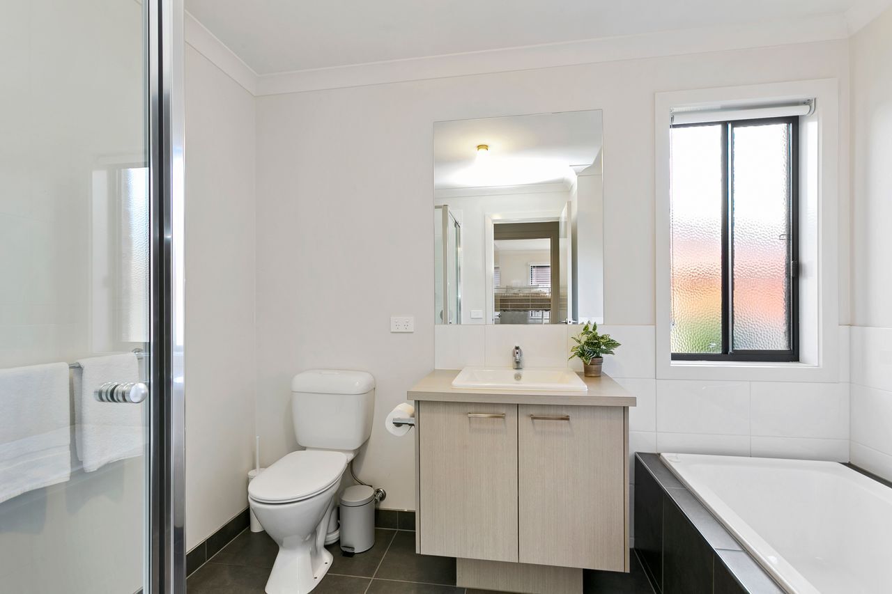 Un baño moderno con inodoro, lavamanos y bañera.