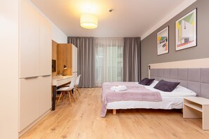 Escritorio, tabla de planchar con plancha, wifi y ropa de cama