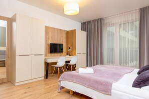 Escritorio, tabla de planchar con plancha, wifi y ropa de cama