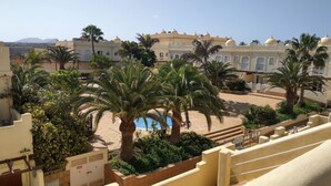 Une cour intérieure agrémentée de palmiers, une piscine et un bâtiment surmonté de toits en forme de dôme.