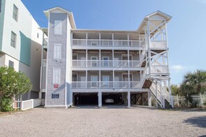 A multi-story building with a central entrance and a staircase leading to a second-floor balcony. - Spacious Oceanfront and Pier Views~ Seaside Villas 202 (Folly Beach)