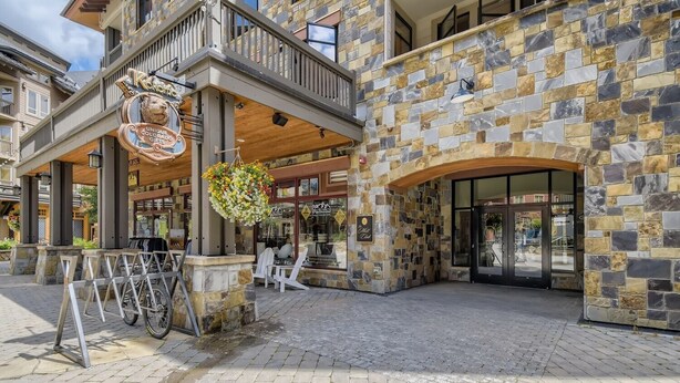 A stone building with a wooden balcony and a sign reading "Unique Colorado Gifts." - Mill Club 2 Bedroom Condo!!  Ski In/Out in Copper's Center Village!! (Copper Mountain)