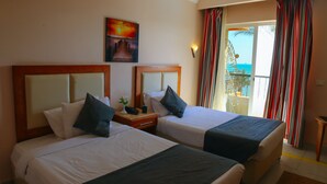 A hotel room with two beds, a painting on the wall, and a balcony with curtains. - Retal View Resort El Sokhna (Ataqah)