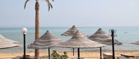 Een privéstrand, parasols, strandlakens, een strandbar