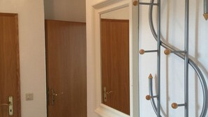 Ein Flur mit Holztüren und einem an der Wand befestigten Hakenleiste.