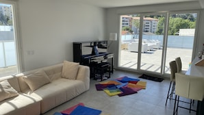 Una sala de estar con un sofá, un televisor y alfombras de colores.
