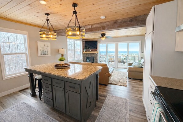 Cocina amplia con una isla grande, iluminación colgante y vistas al exterior.