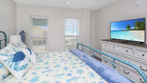 A bedroom with a bed, a television, a dresser, and a ceiling fan. - Gulf Front, NW Top Floor Condo on Side Street in MXB ~ Surfside 17 (Mexico Beach)