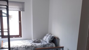 A bedroom with two single beds, a window with blinds, a ceiling light, and a wooden ladder. - As close to the beach as you can possibly get !!!  uninterrupted estuary views (Exmouth)