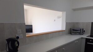 A modern kitchen with grey cabinets, a built-in oven, a microwave, and a window above the sink. - As close to the beach as you can possibly get !!!  uninterrupted estuary views (Exmouth)