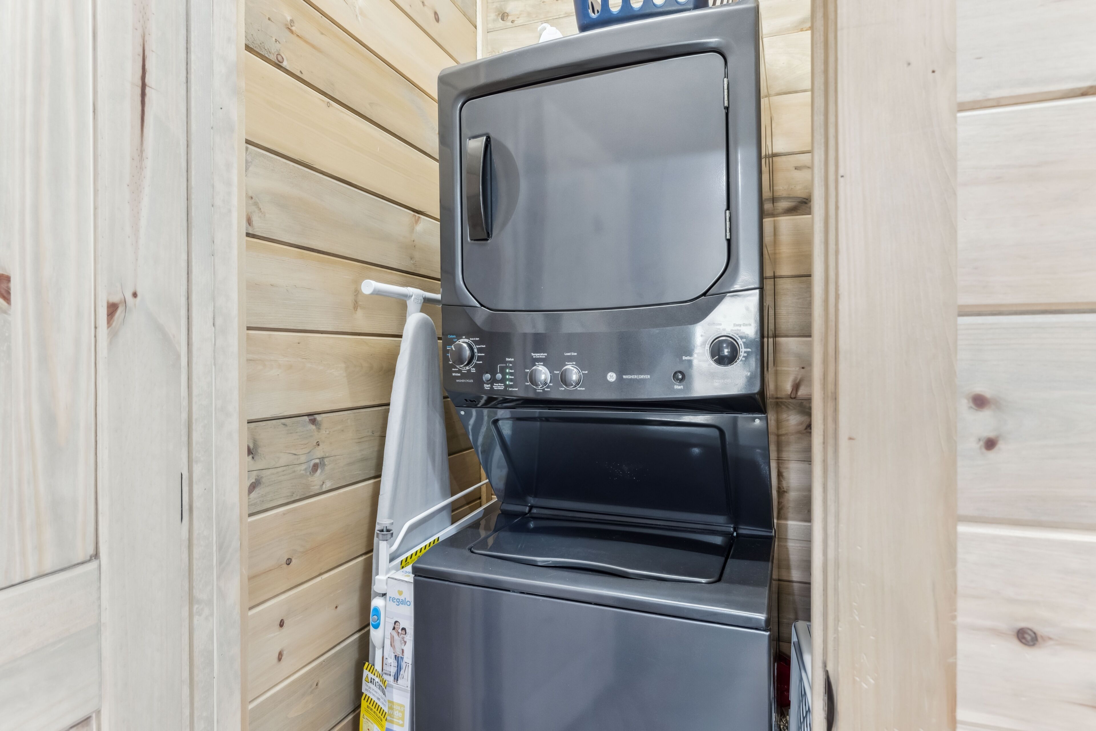 A compact, wall-mounted washer and dryer unit with a control panel and a small window.