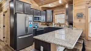 Una cocina moderna con encimeras de granito, electrodomésticos de acero inoxidable y paneles de madera.
