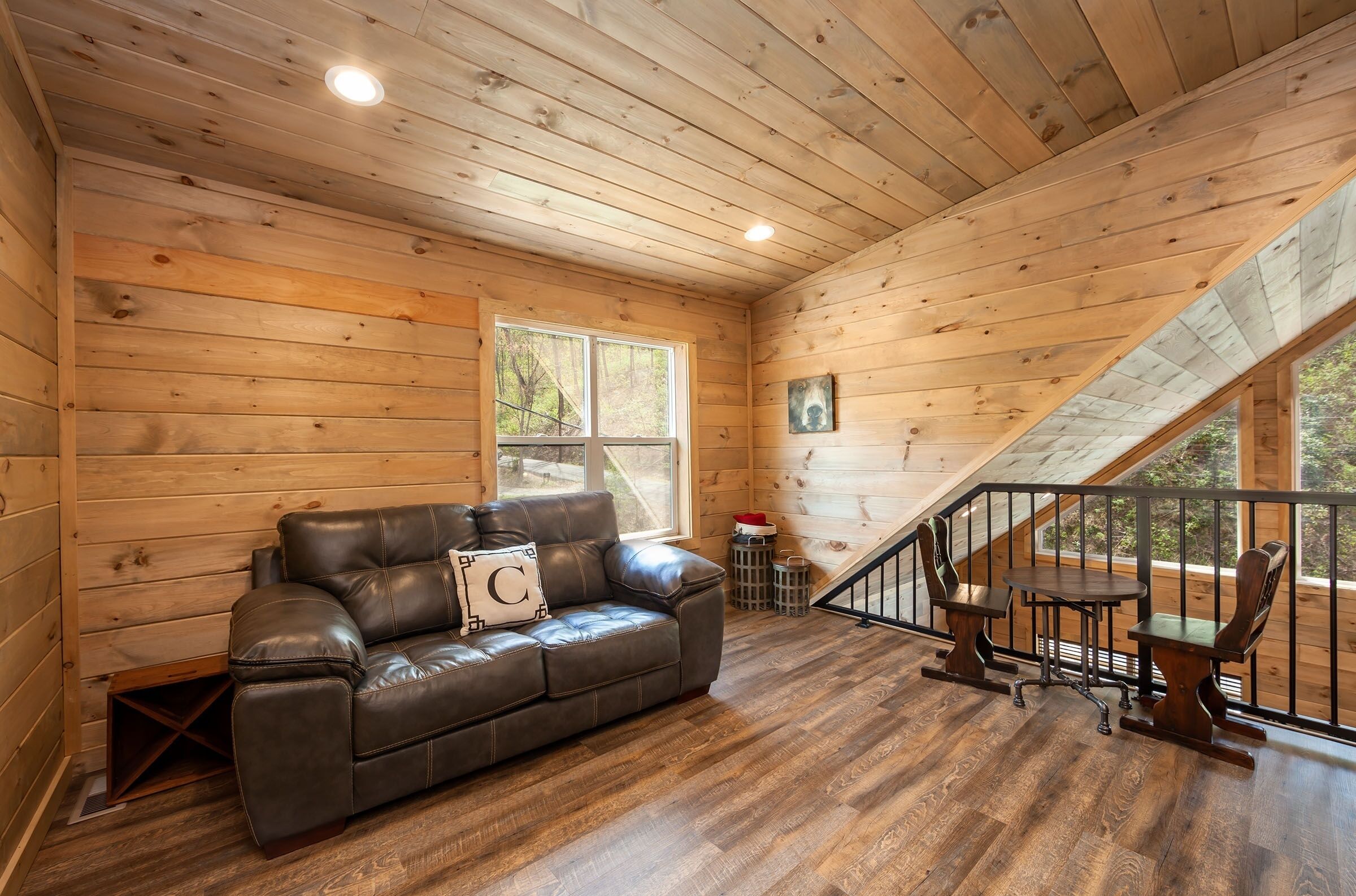 A wooden interior with a leather sofa, a small table, and chairs.