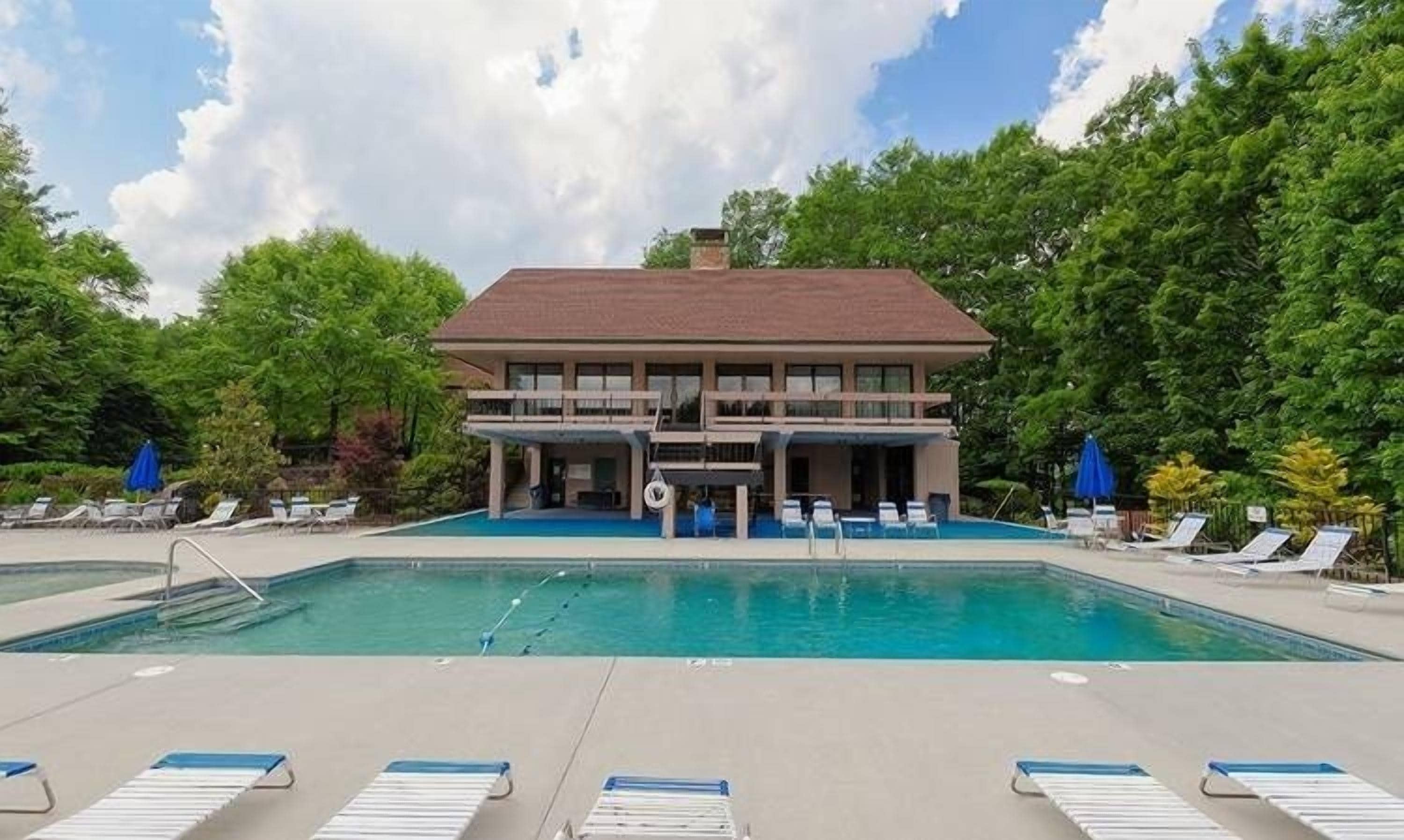 Un bâtiment à deux étages avec une piscine devant.