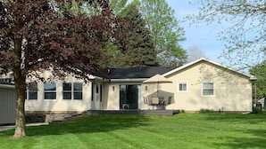 A single-story house with a covered patio and a lawn. - Lake Front home near Sister Lakes area.  Pontoon rental available. (Decatur)