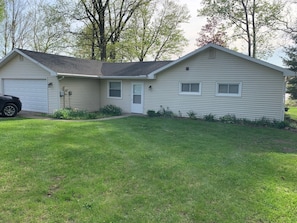 A single-story house with a garage, a front door, and a small porch area.