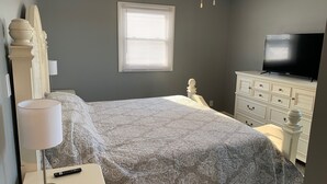 A bedroom with a bed, a dresser, a TV, and a window with blinds. - Lake Front home near Sister Lakes area.  Pontoon rental available. (Decatur)