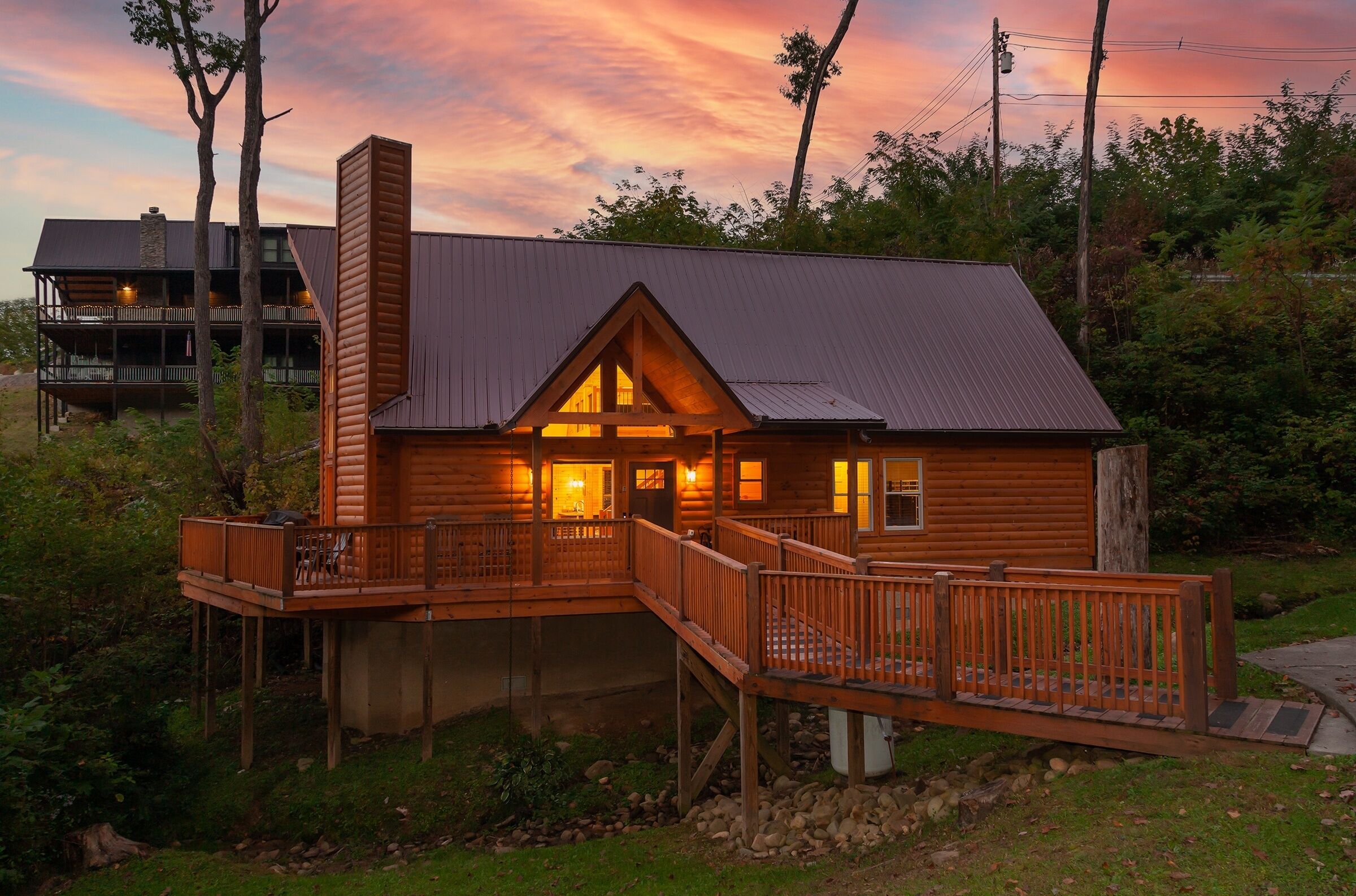 A wooden cabin with a deck, a chimney, and a balcony.