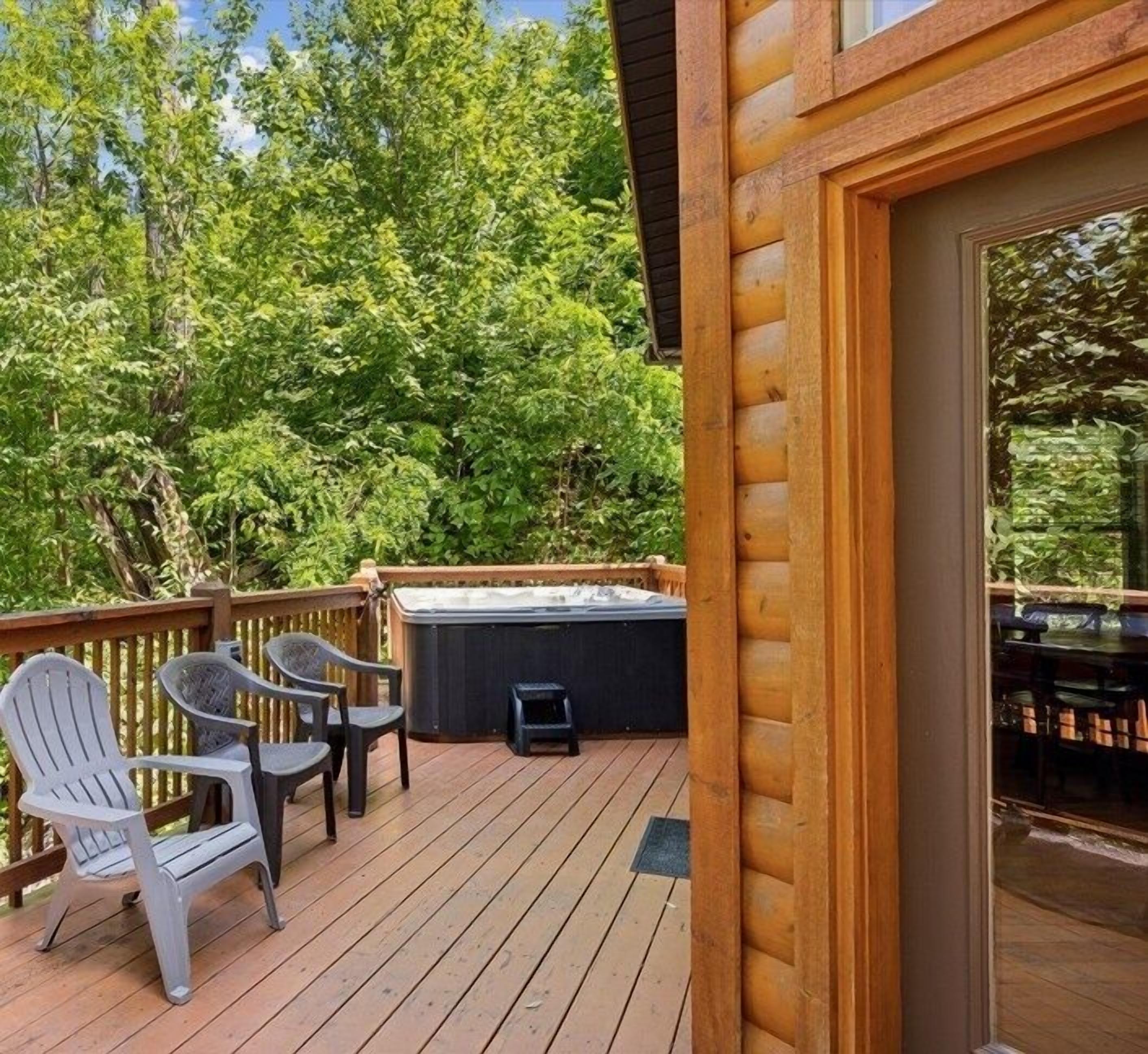Eine Holzterrasse mit Außenmöbeln und einem Whirlpool.
