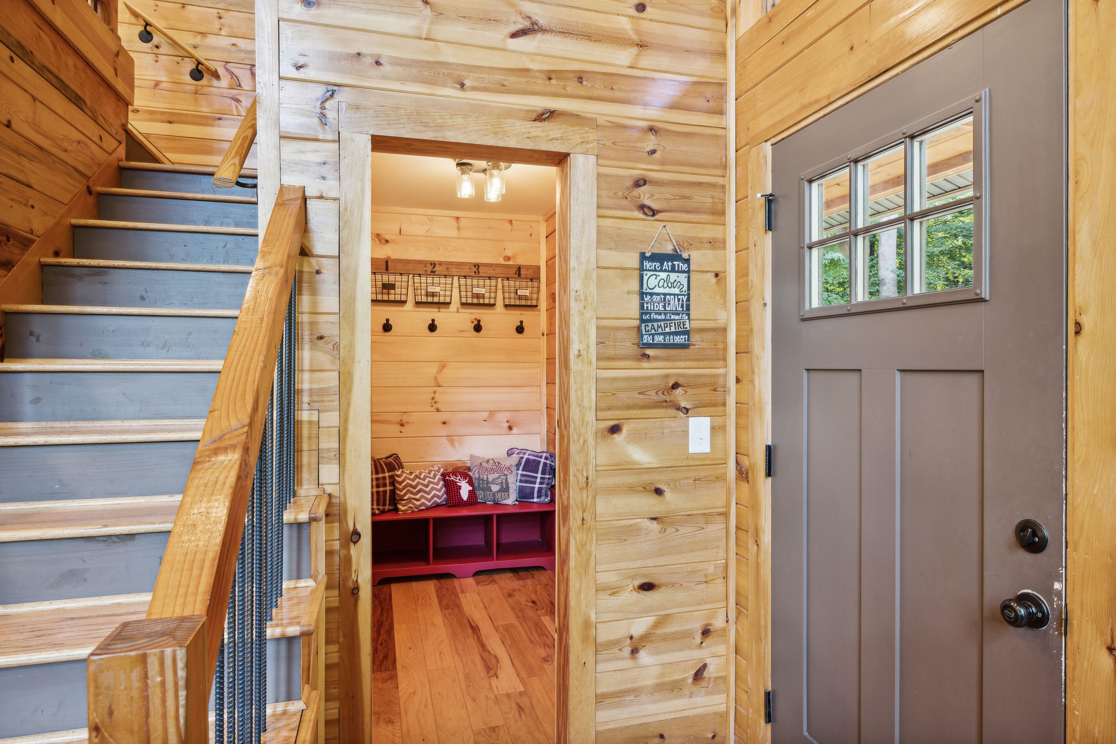 A wooden staircase leading to a room with a door and a window.