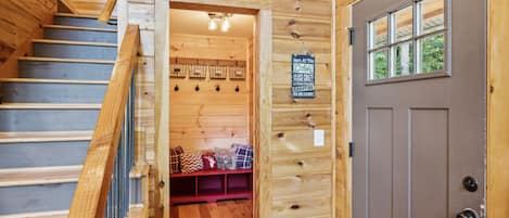 A wooden staircase leading to a room with a door and a window.