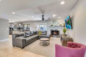 A modern living room with a sectional sofa, a round coffee table, and a fireplace.