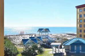 Blick auf einen Strand mit blauem Himmel, Sandstrand und mehreren Gebäuden mit blauen Dächern.
