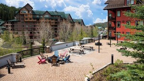 A rooftop patio with outdoor seating, a view of a lodge, and a red building. - Fraser Crossing 3518 remodeled studio gas fireplace and views (Winter Park)